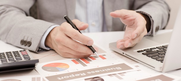 Businessman analyzing investment charts with laptop. Accounting